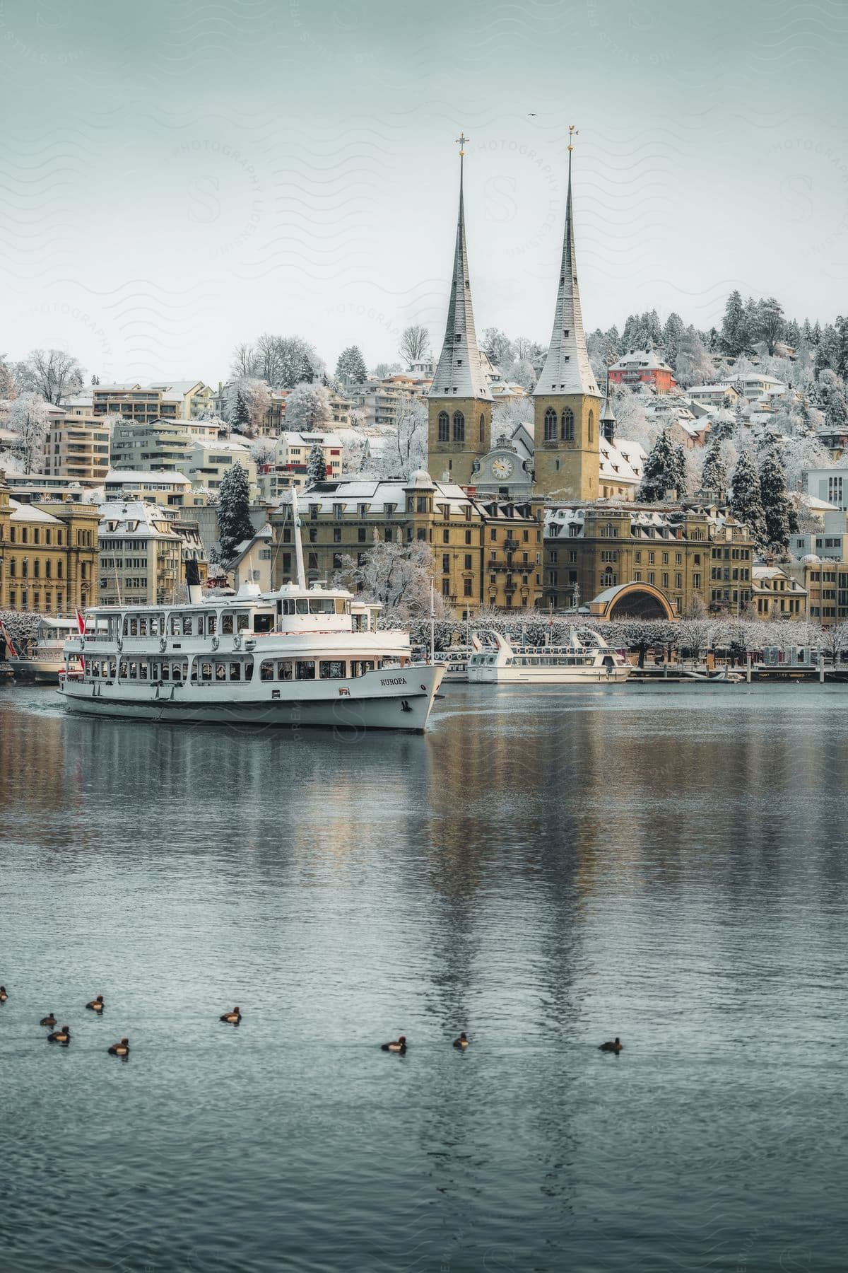 A river boat departing a city covered in snow.