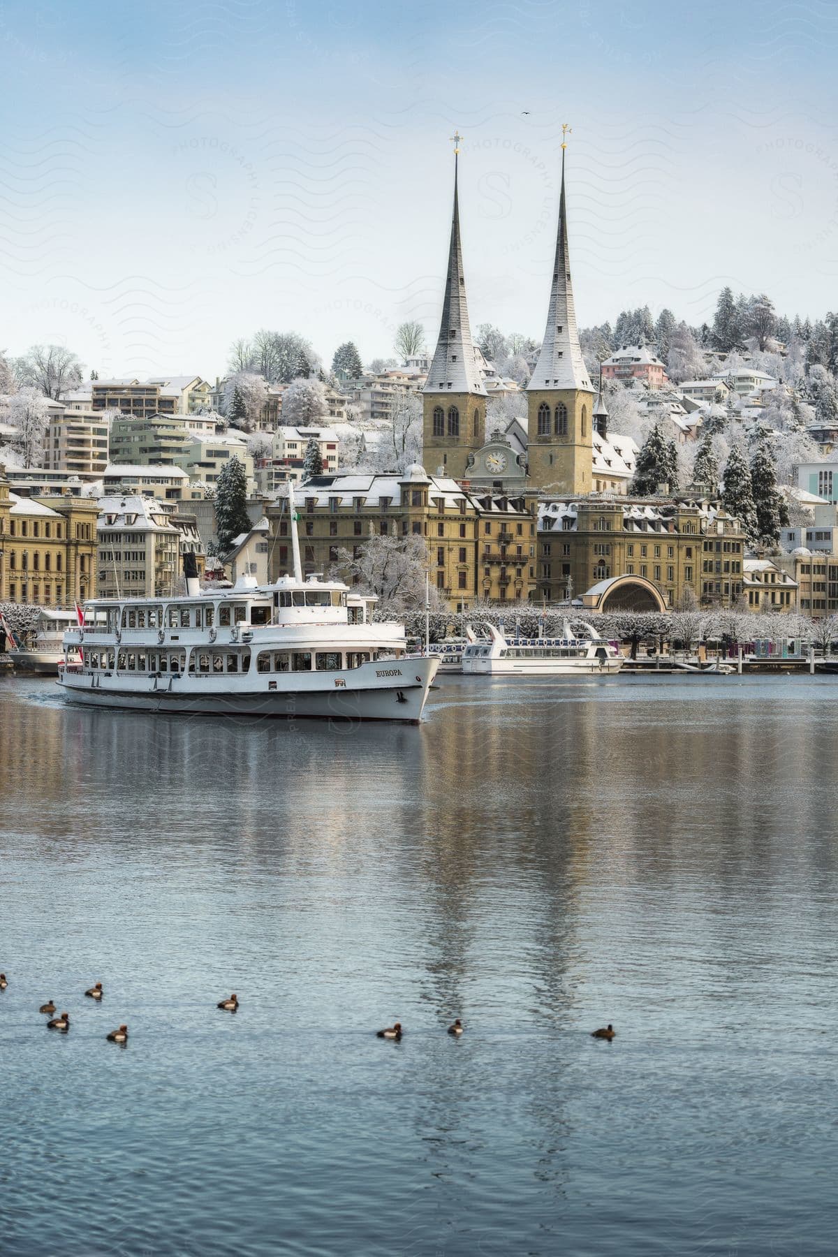 Ferries sailing in the sea of a coastal town covered in snow during winter.