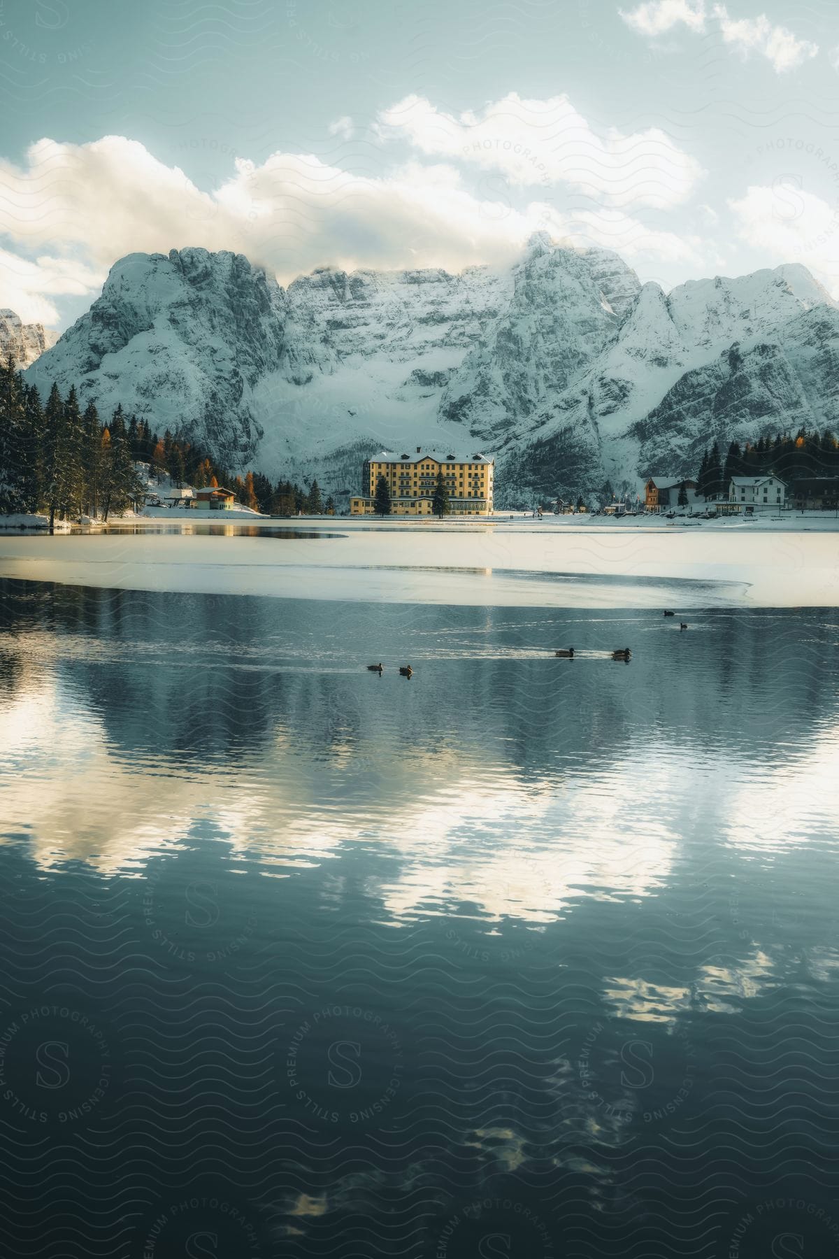 Landscape of Lake Misurina with hotel and houses and snow-covered mountains in the background