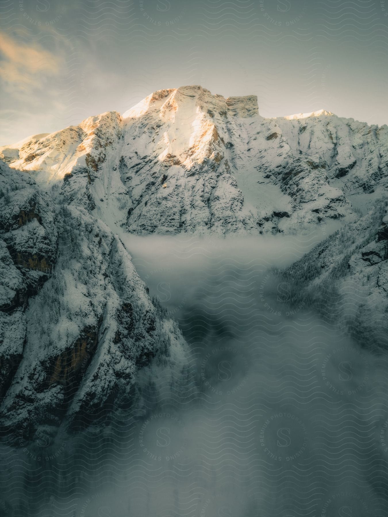 A snowy mountain range with dawn slowly coming