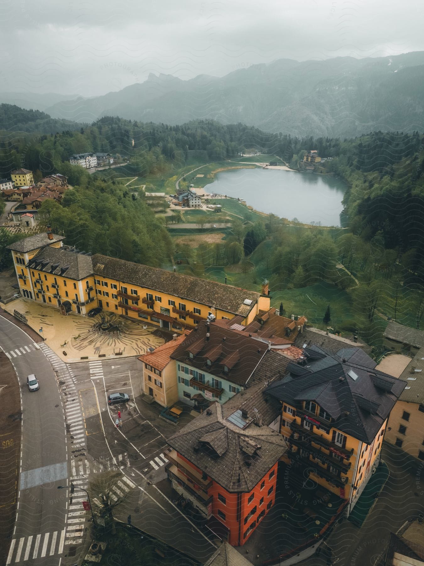 Aerial panorama of the Grand Astoria hotel with mountains around on a lake on a cloudy day