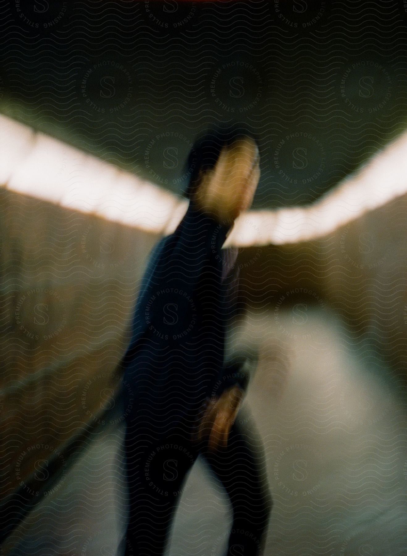 Blurry tunnel figure in black, walking away.