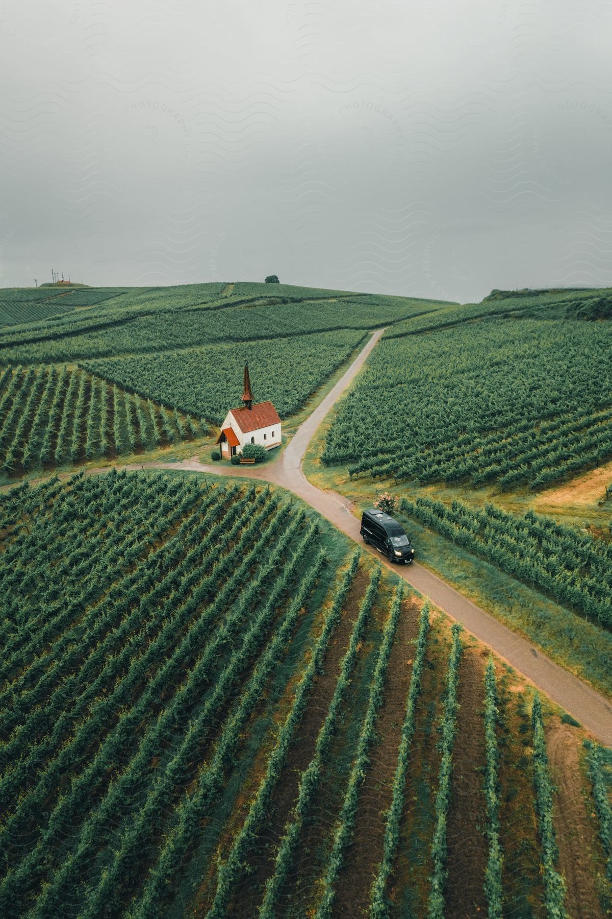 Van traveling on a rural road near a church in the middle of farmland