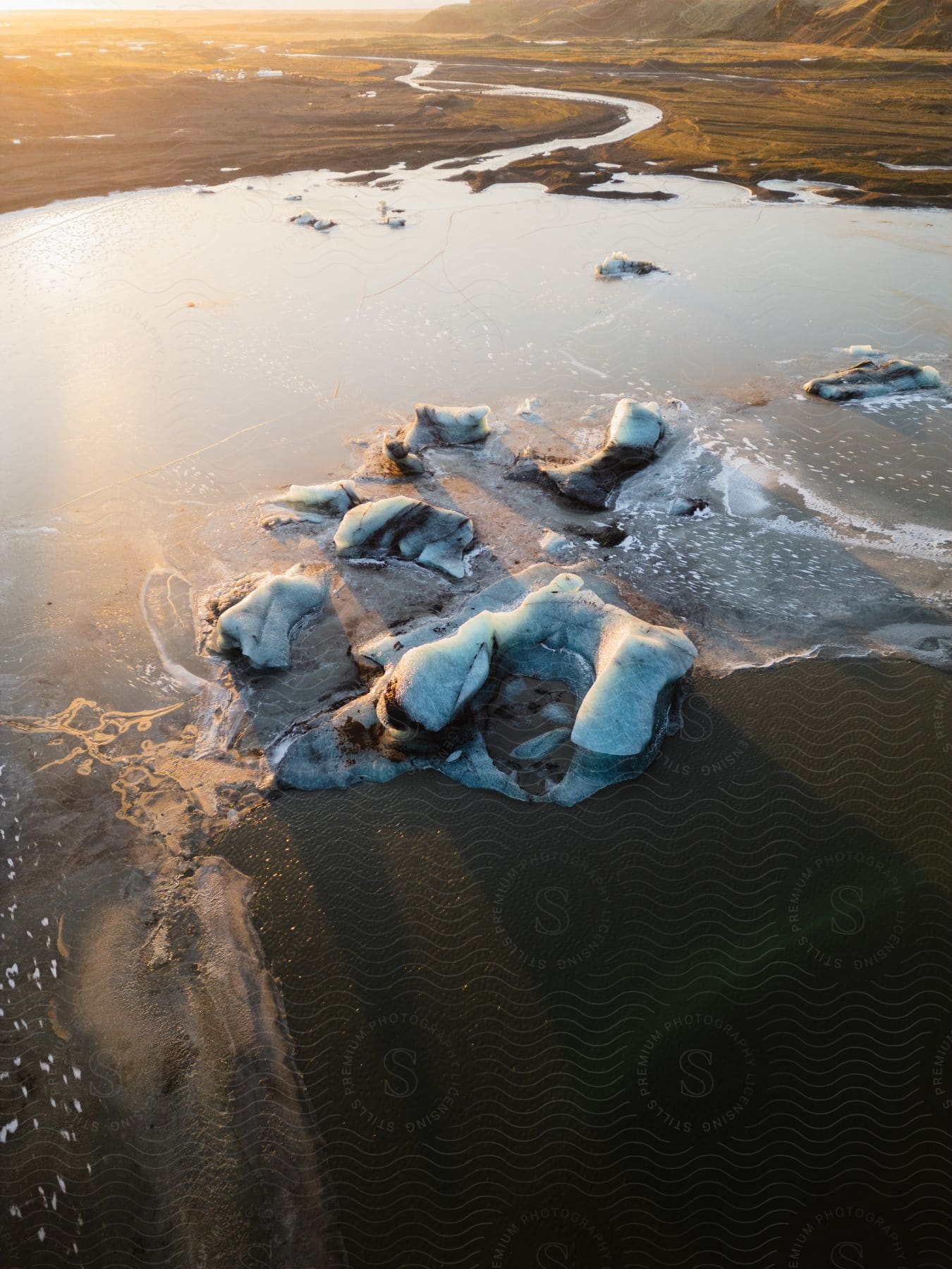 Landscape of a sandy ground covered by foamy water and the sun's reflection