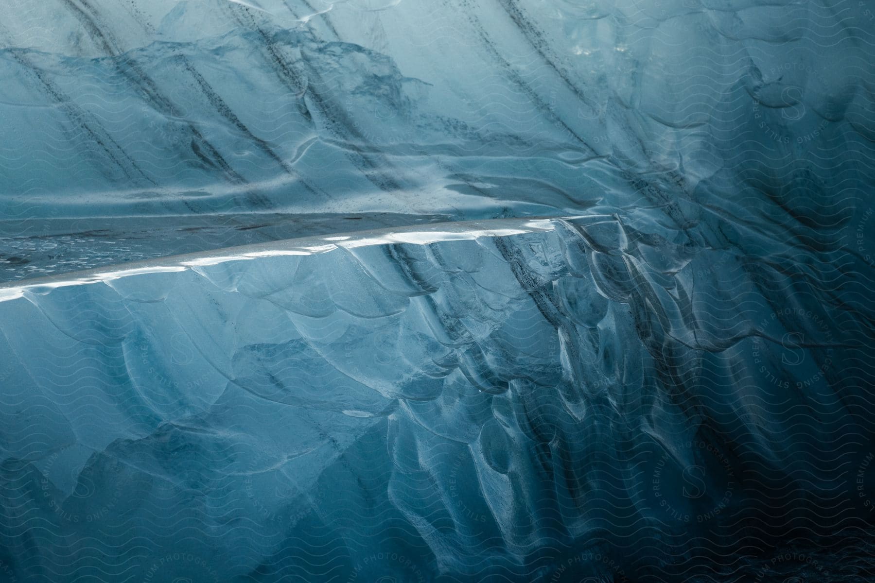 a close-up of light blue ice in a cave, with darker blue veins running through it.