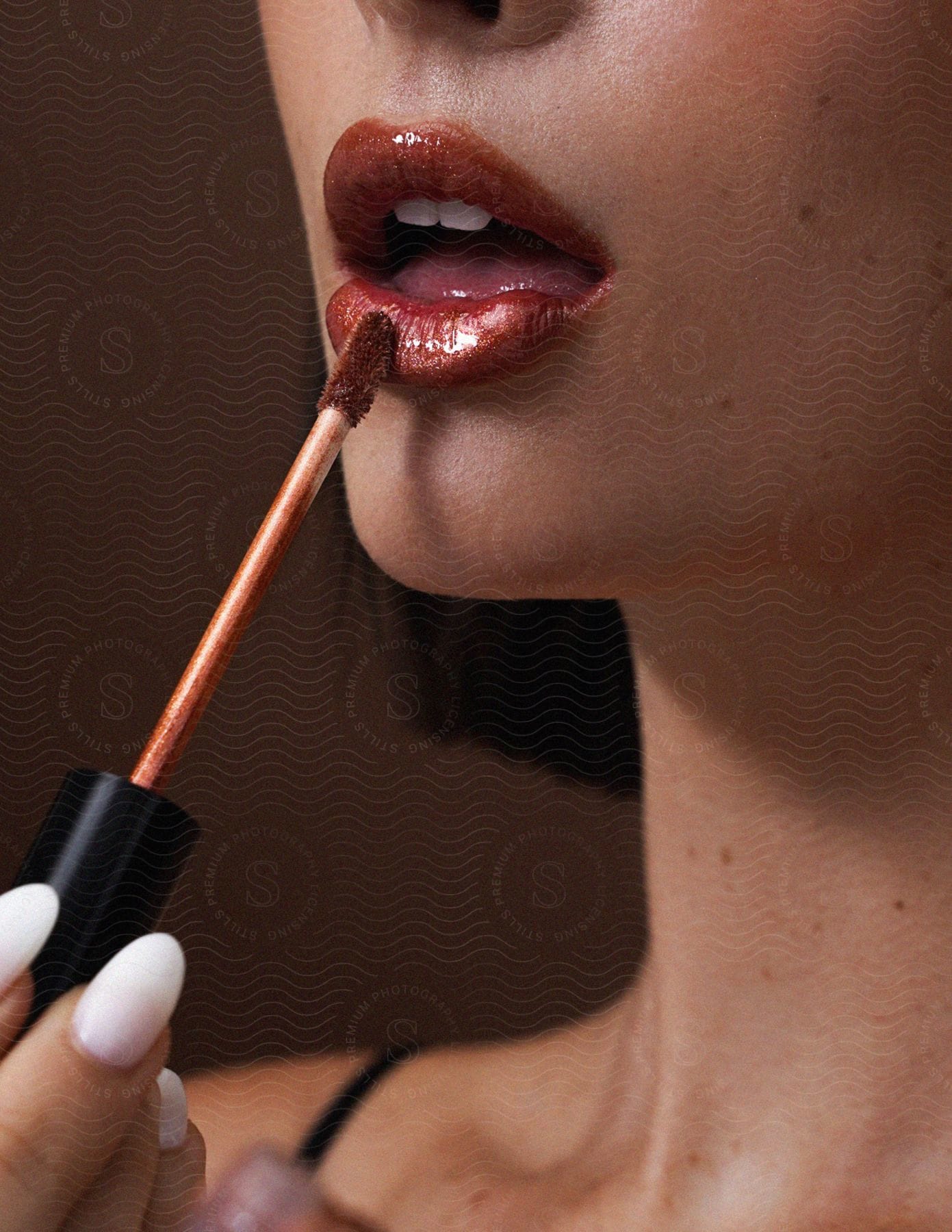 A woman applying red lipstick with a brush.