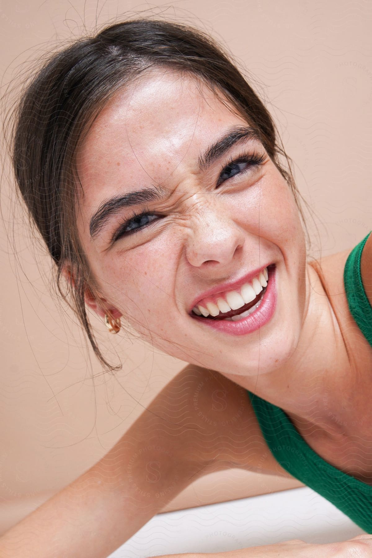 Closeup of woman smiling broadly and scrunching up her nose.