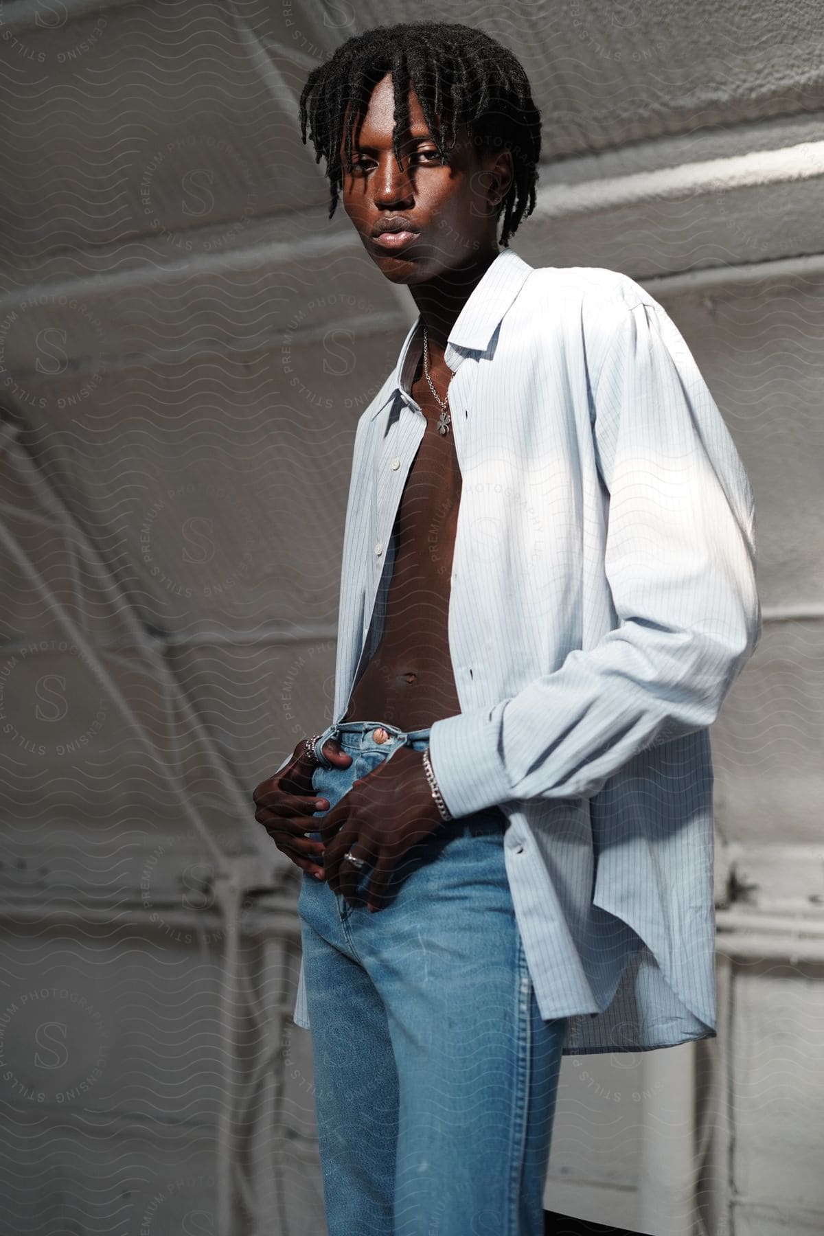 A man modeling some clothes indoors in a room.