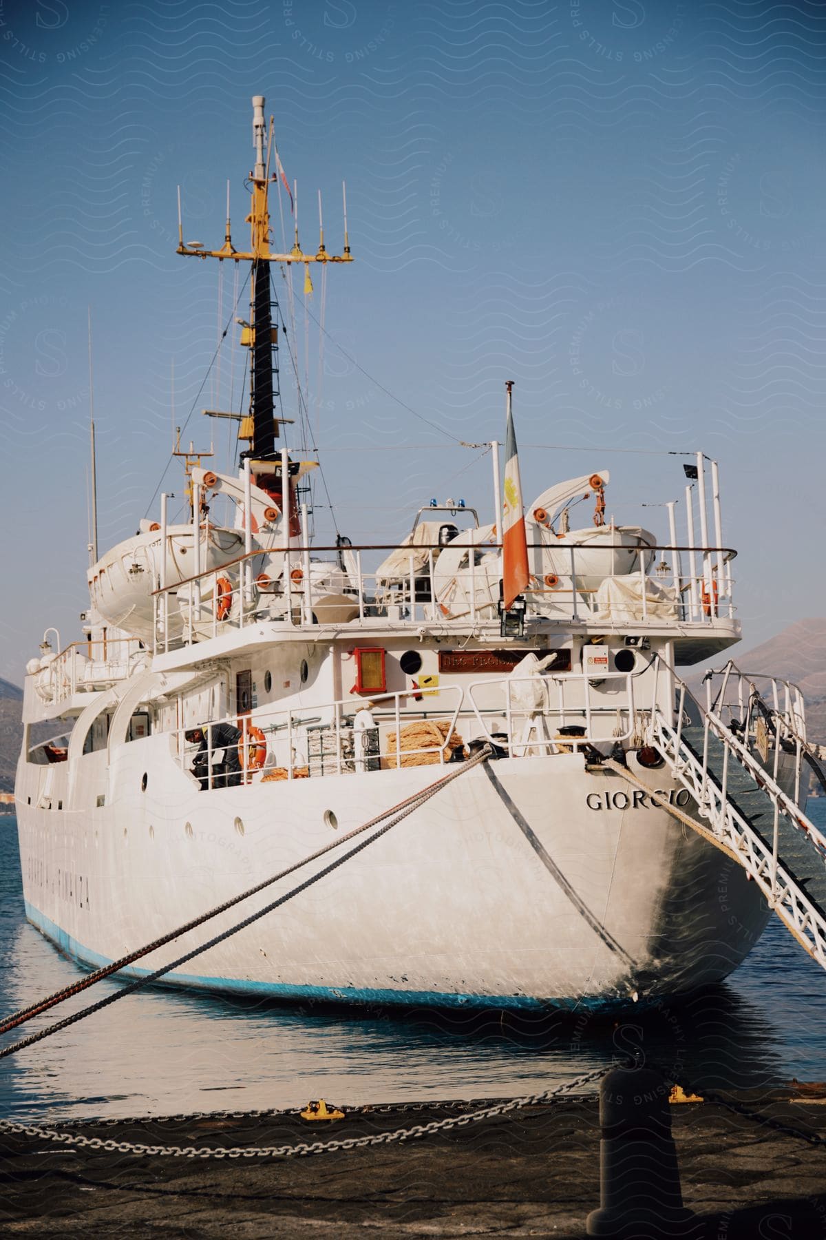 White research vessel moored at dock with clear skies in the background.