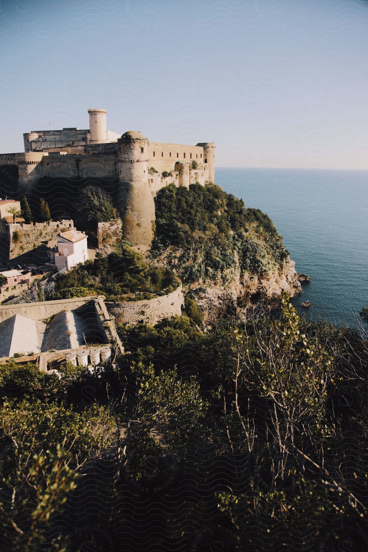 A cliff-top fortress with thick walls and towersnext to the ocean