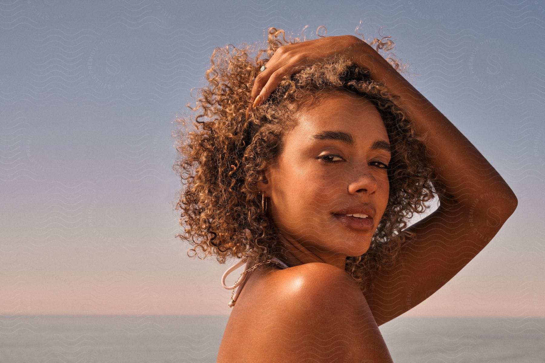 Close-up of a woman outdoors on a beach on a sunny summer day.