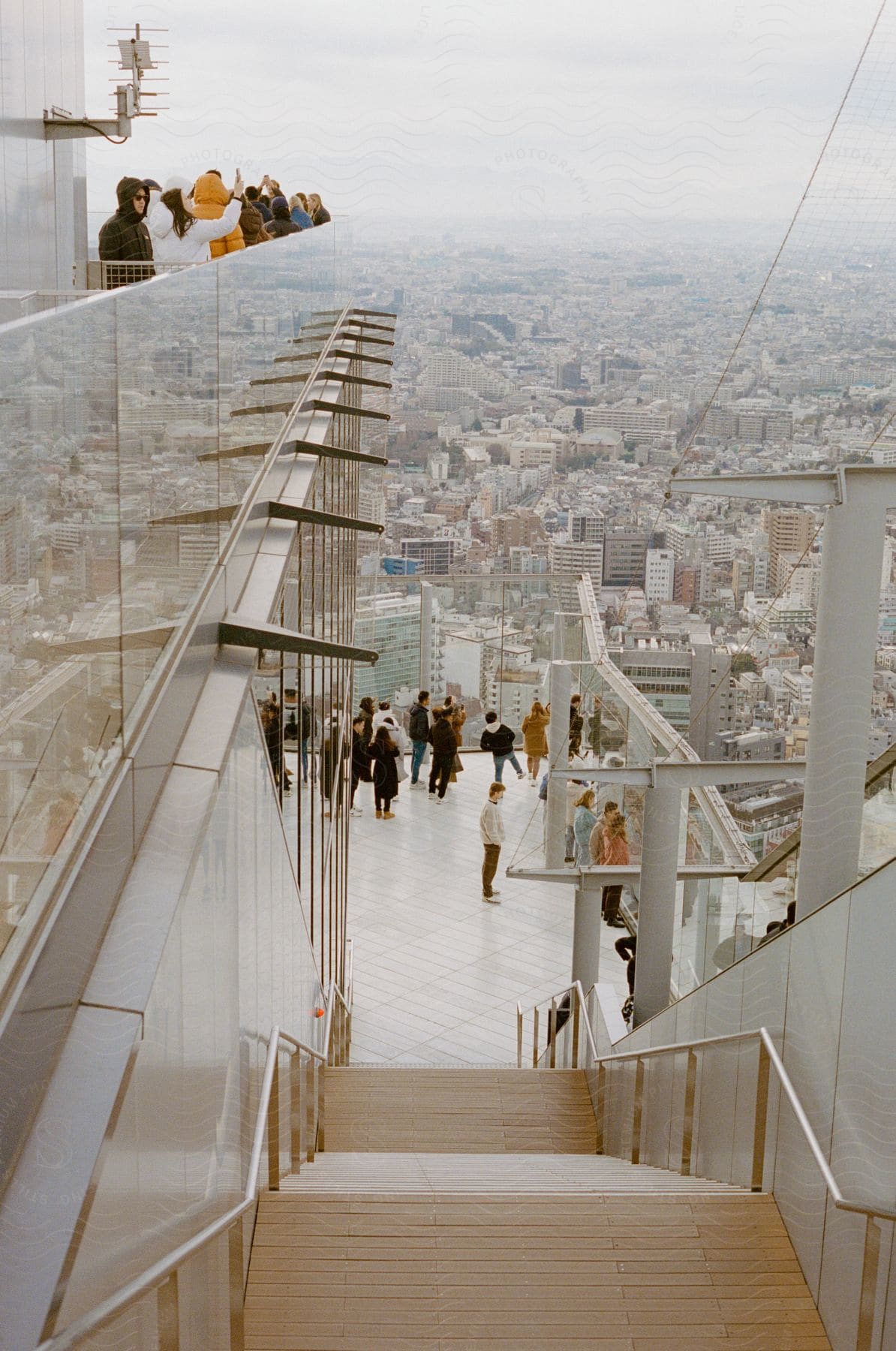 A crowded observation deck offers a hazy view of Tokyo's concrete sprawl.