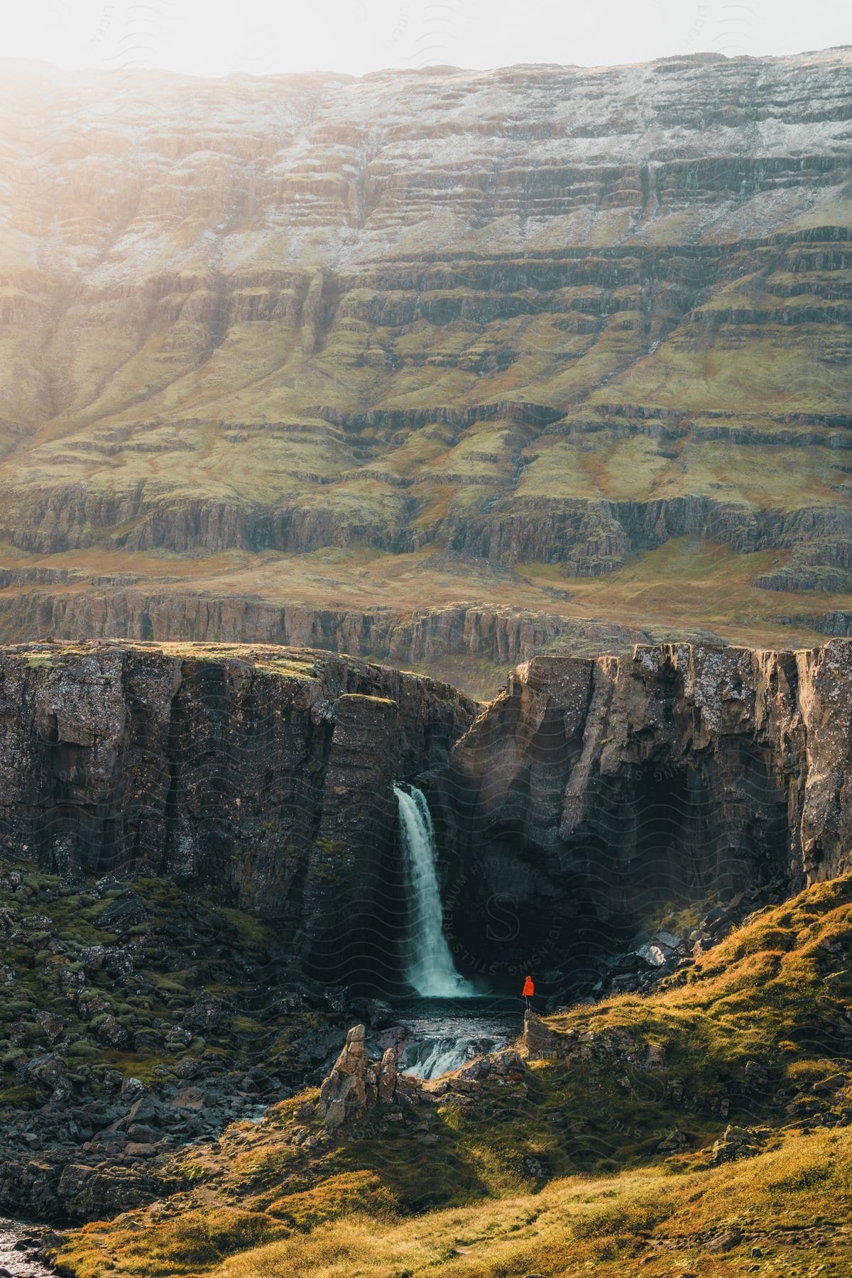 A view of a massive canyon with a waterfall in it.