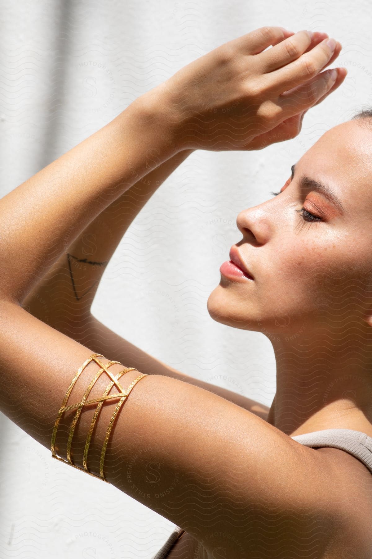 A woman modeling some jewelry outdoors on a sunny day.