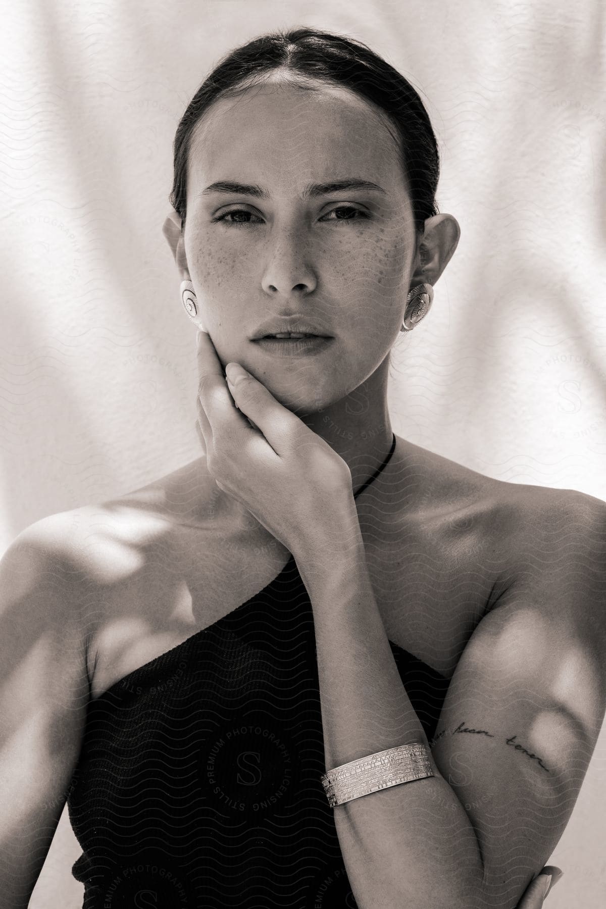 A woman posing for a photo, caressing her own chin