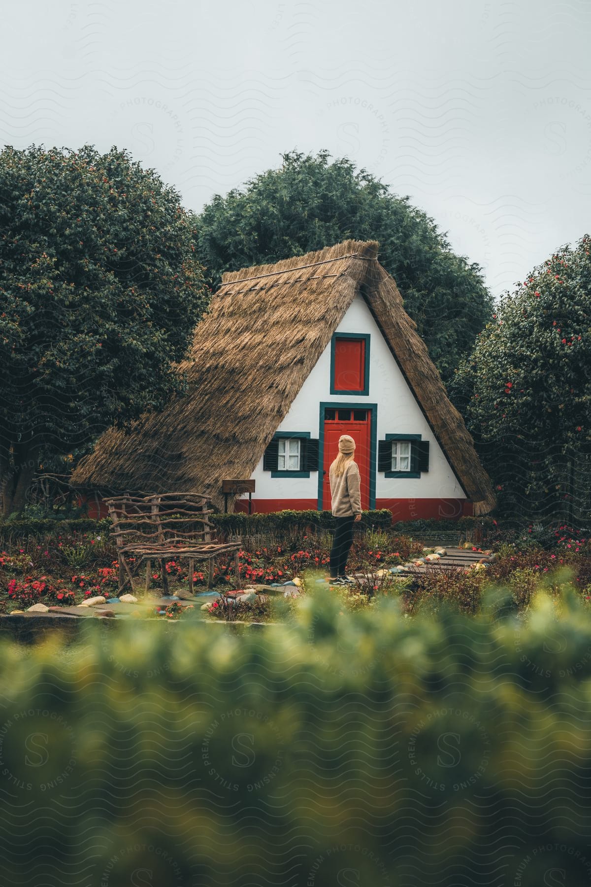 Exterior architecture of a cabin model house with a blonde person observing on a cloudless blue sky day