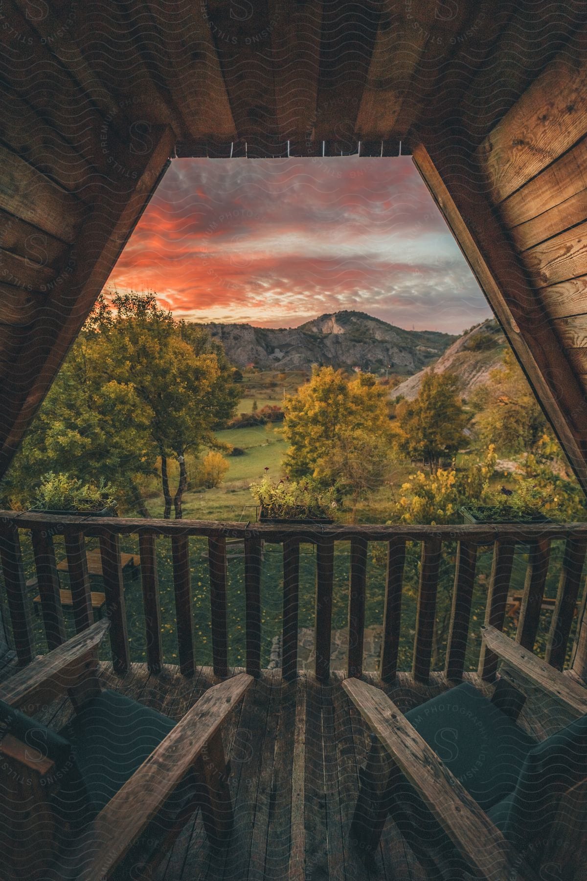 A stunning view of a natural landscape at sunset seen from inside a wooden cabin.