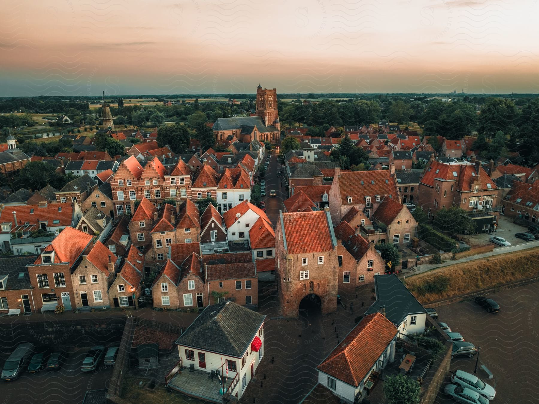 Serene aerial of a historic city with red roofs at sunset.