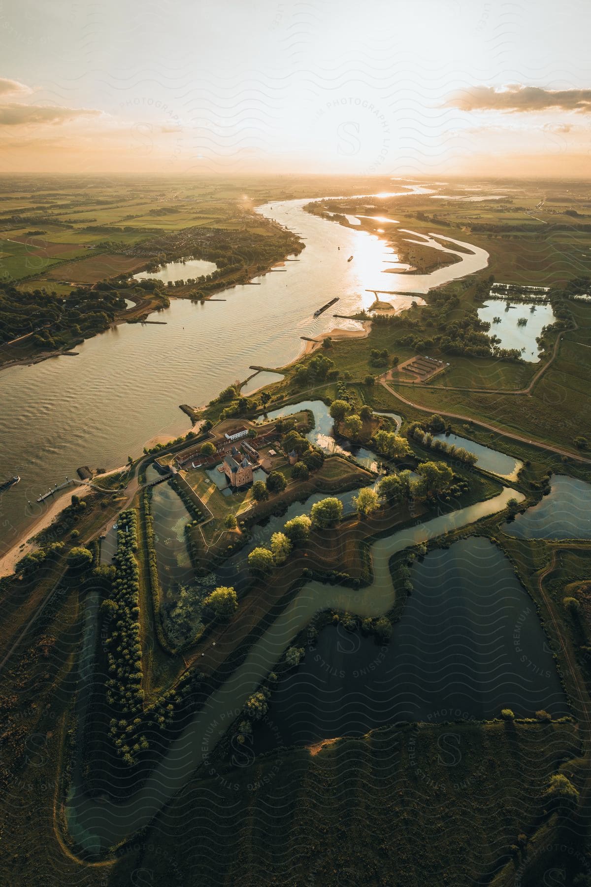 A large house surrounded by a huge plot of land with several rivers, lakes and lots of green vegetation