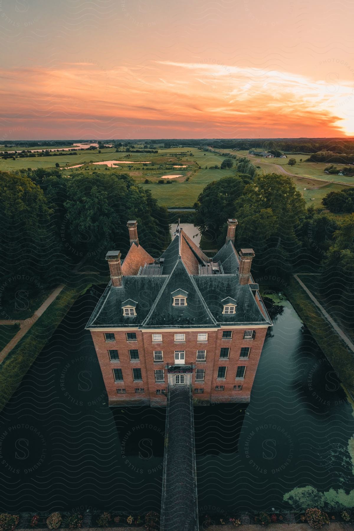 Stock photo of aerial panorama of the castle amerongen museum in a late afternoon with an orange sky.