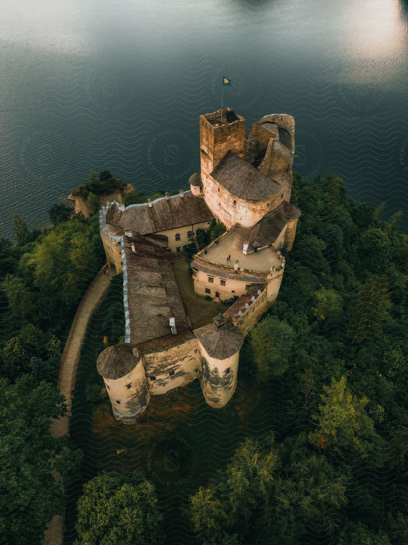 An aerial view of a castle outdoors next to some water.