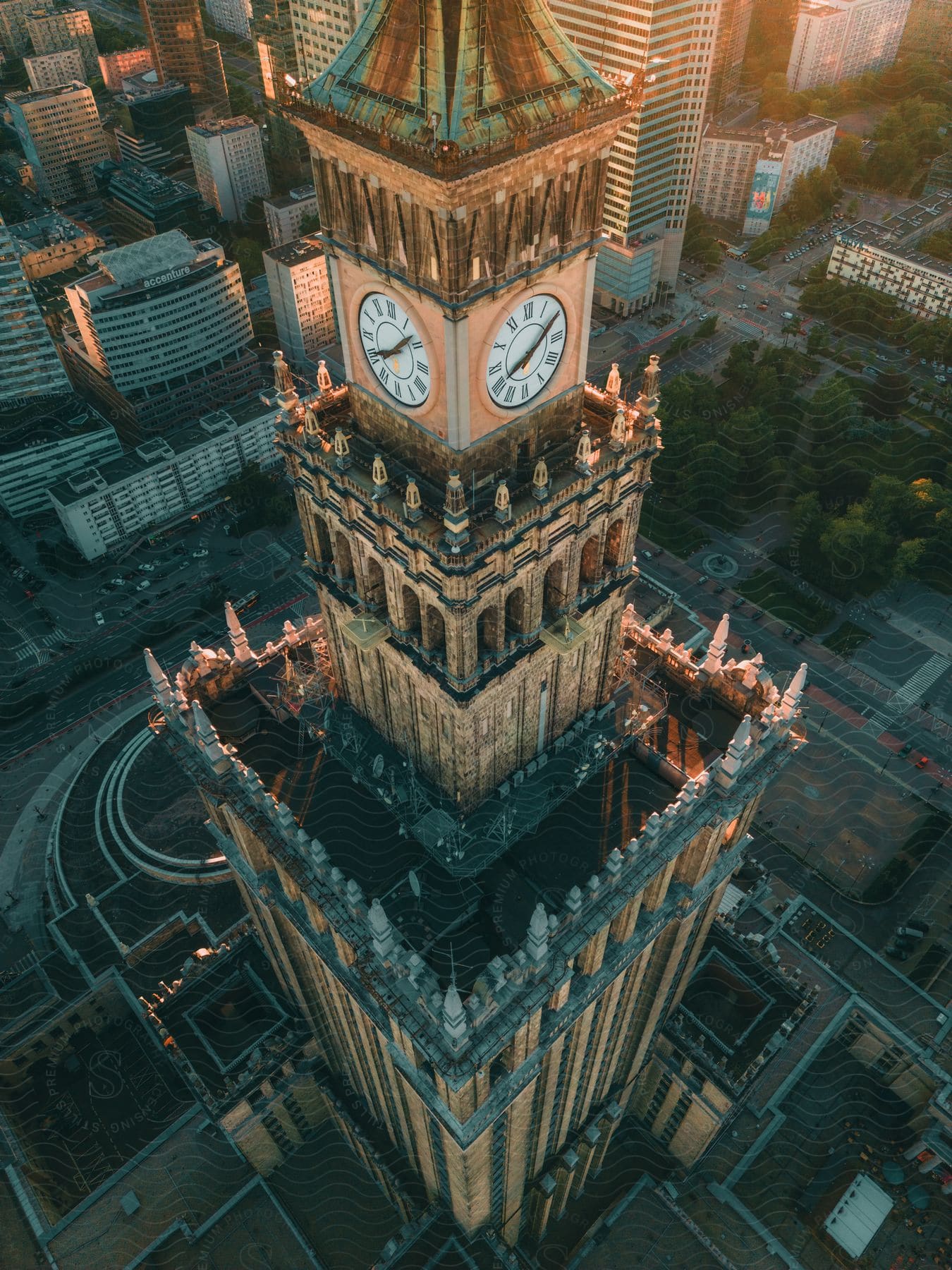 A view of a large clock tower in the middle of an urban area.