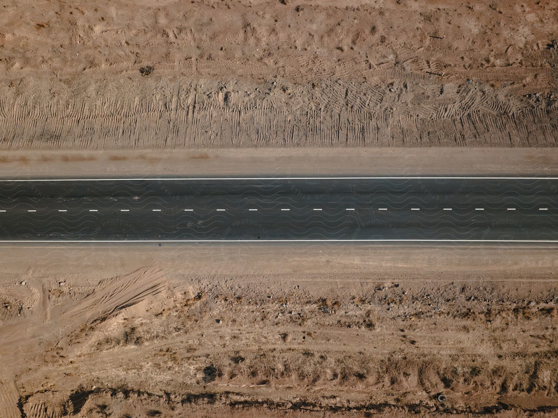 An aerial view of a highway cutting through arid land