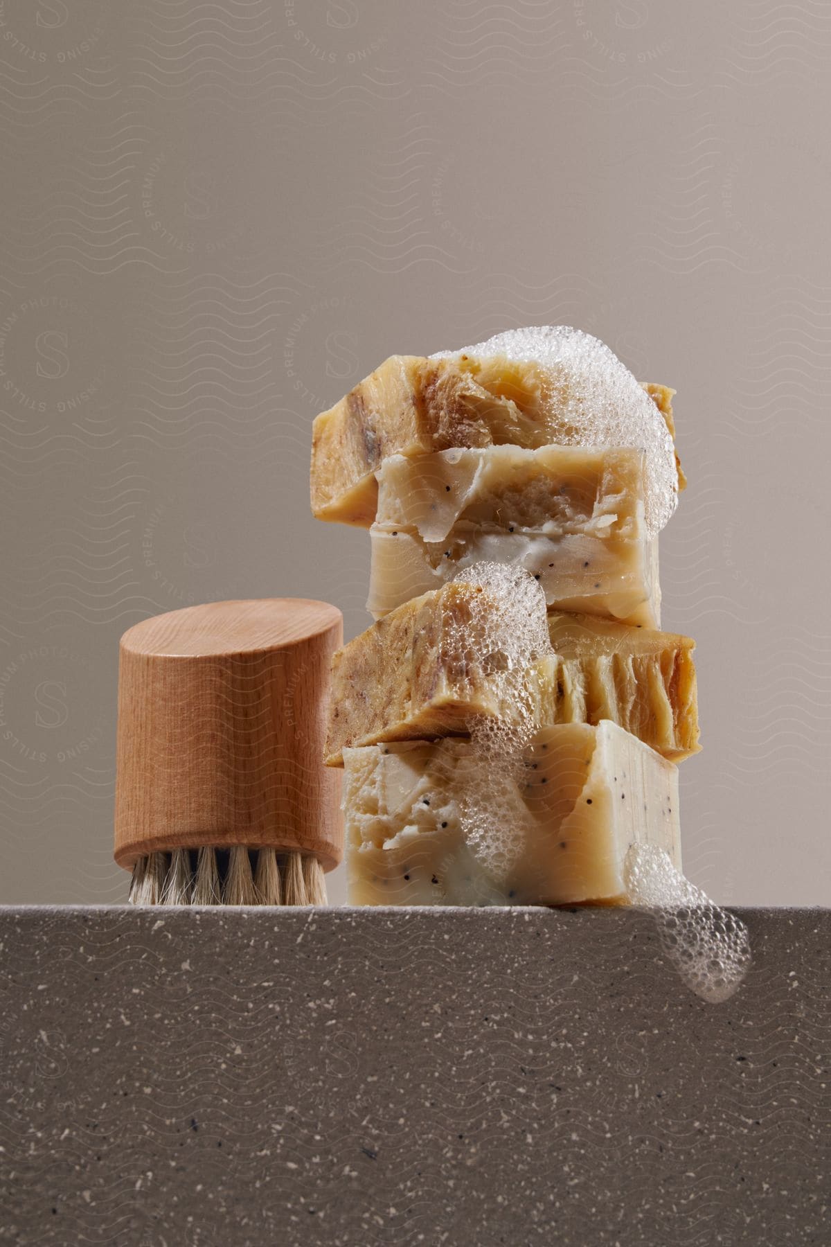 Some soap and a brush sitting on a table.