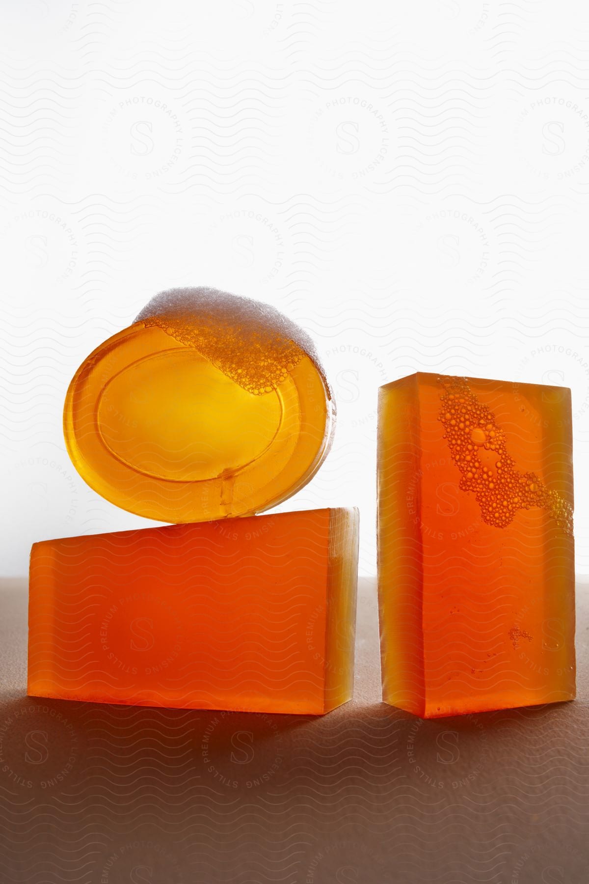 Translucent bars of soap stand on edge with bubbles on the surface