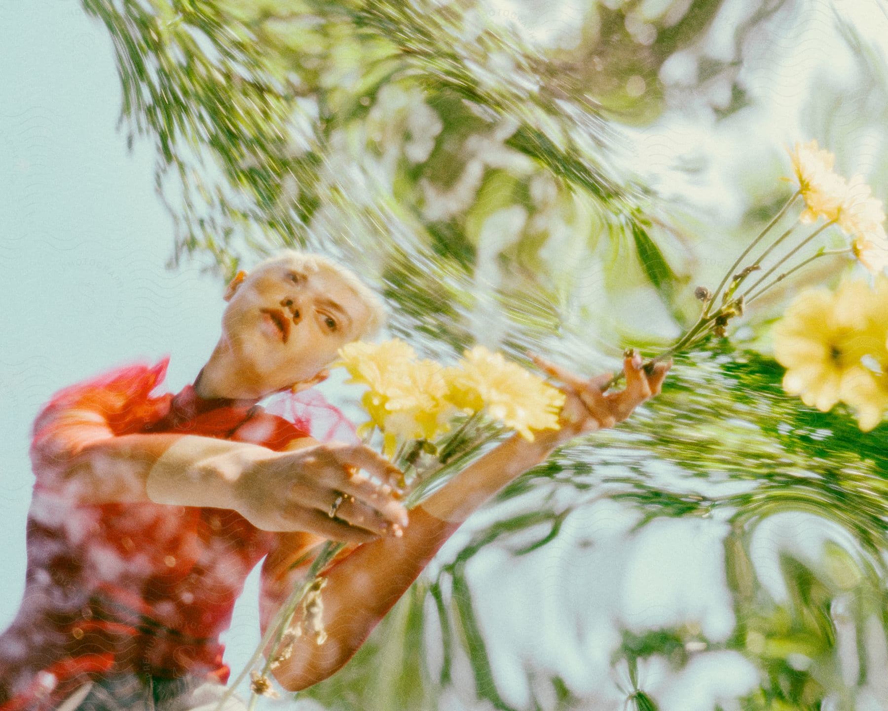 Reflection on the water of a woman holding yellow flowers