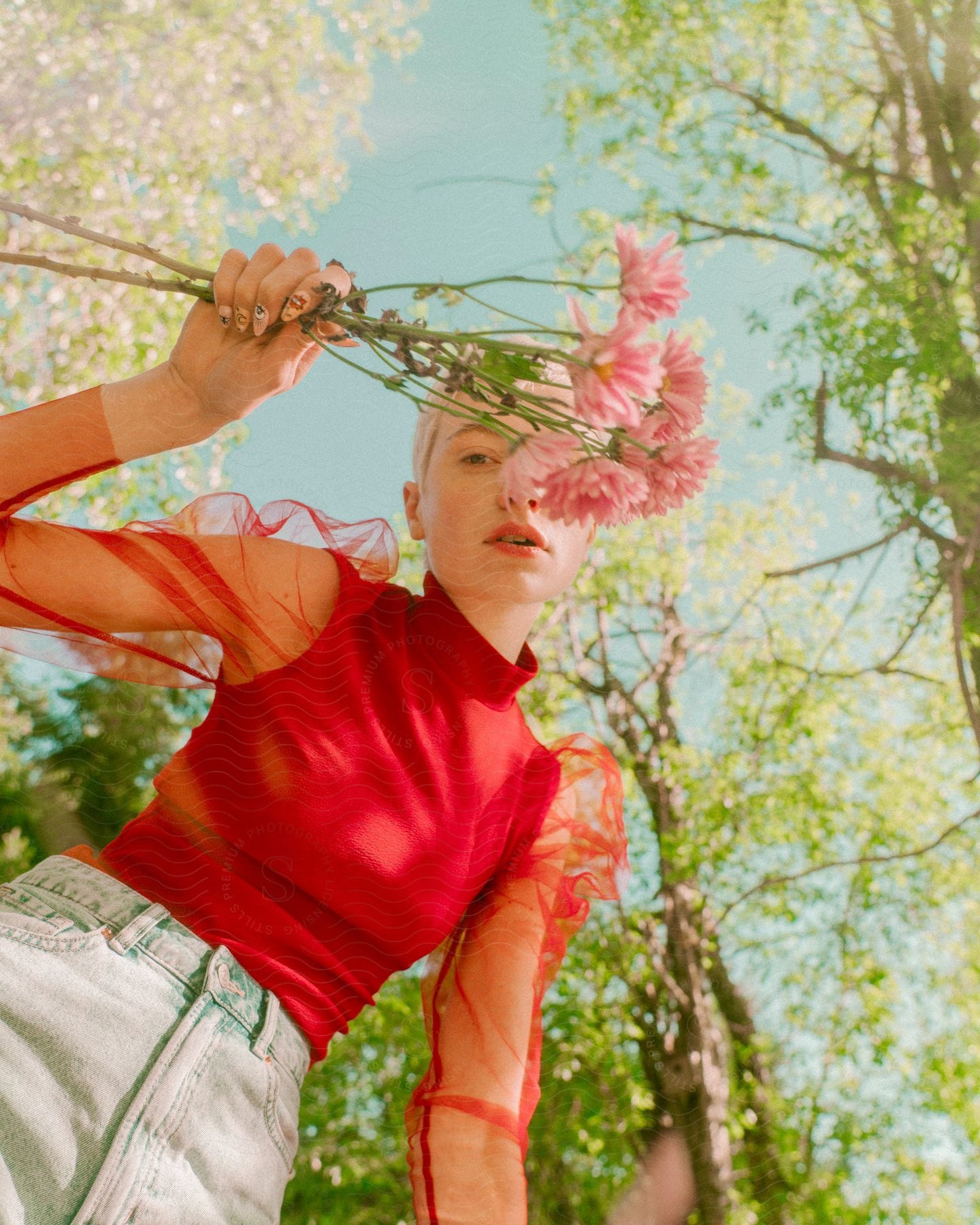 Model in a garden holding bouquet of light pink flowers