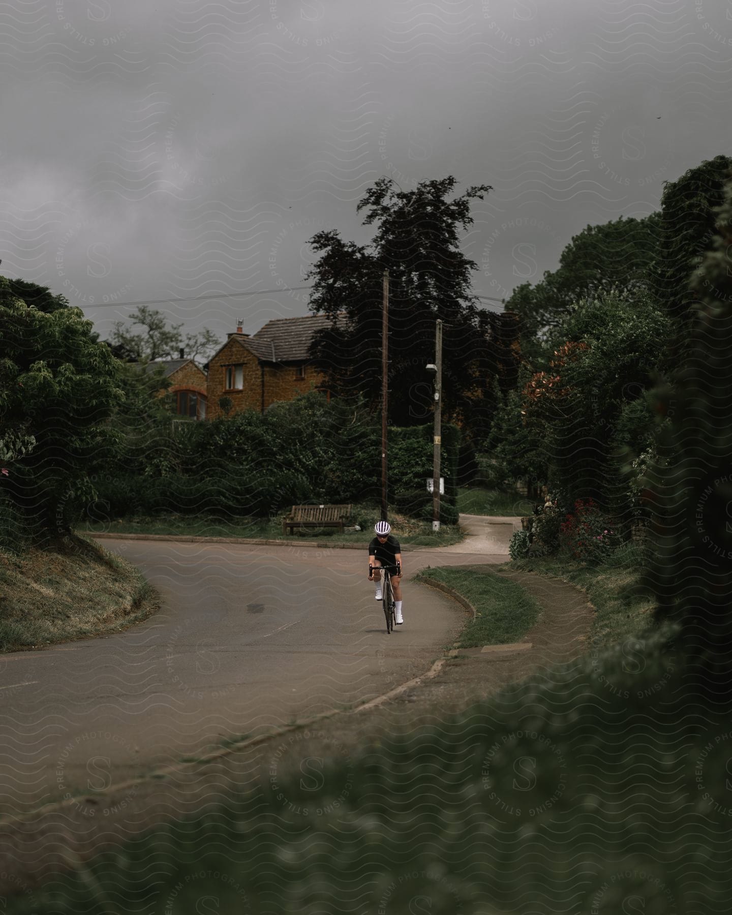 A cyclist rides a bicycle around the curve of a neighborhood street