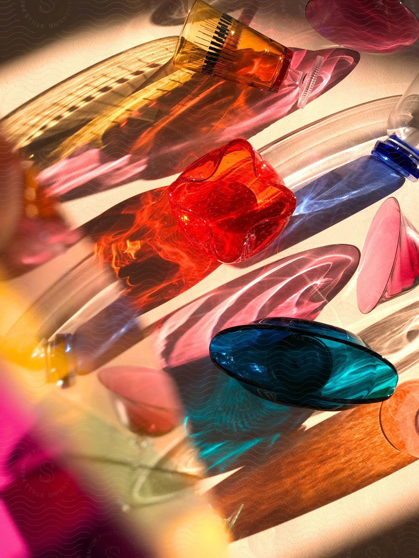 A bright light shines on various pieces of bright colored glass.