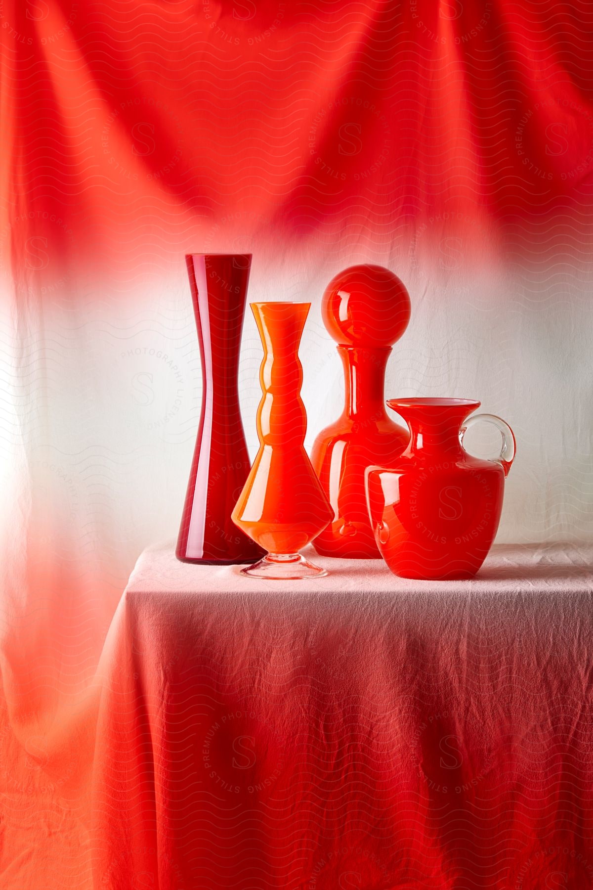 An array of red glassware artistically arranged on a draped table.