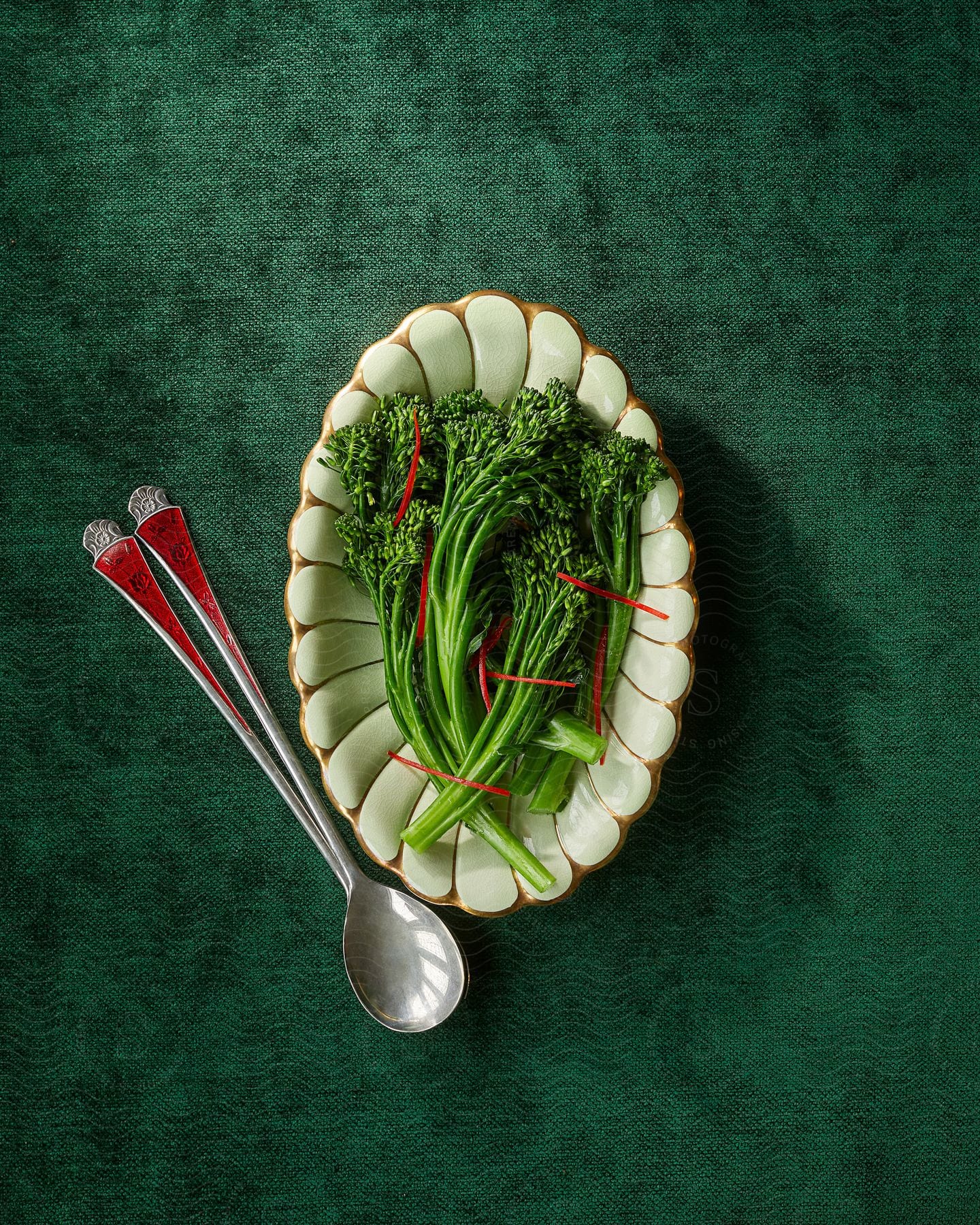 A Container With Various Green Vegetables And There Is A Spoon Next To It