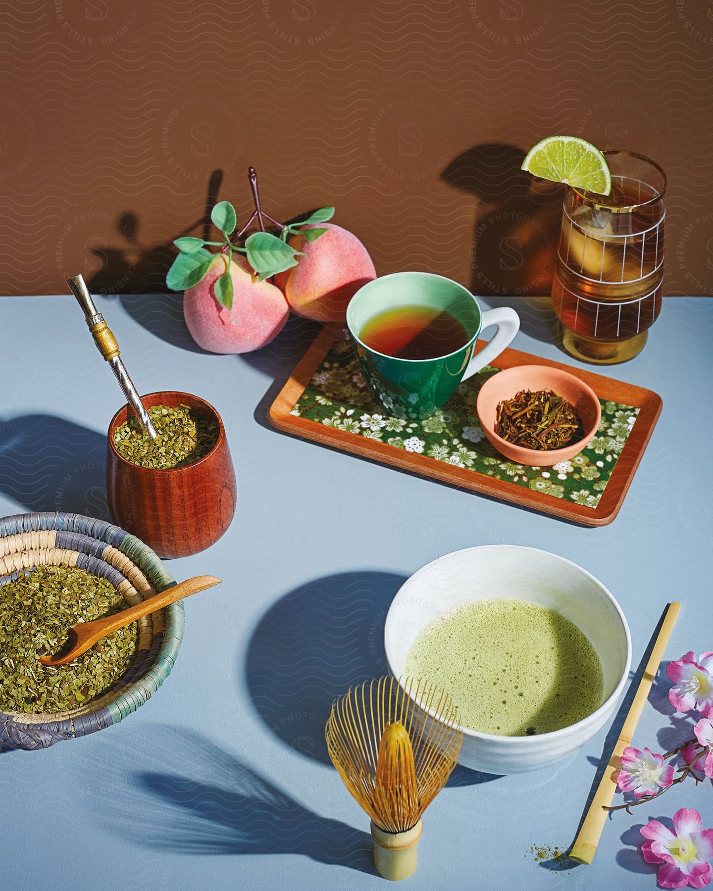 A white table full of containers with green liquids and some herbs and fruits found in the surroundings