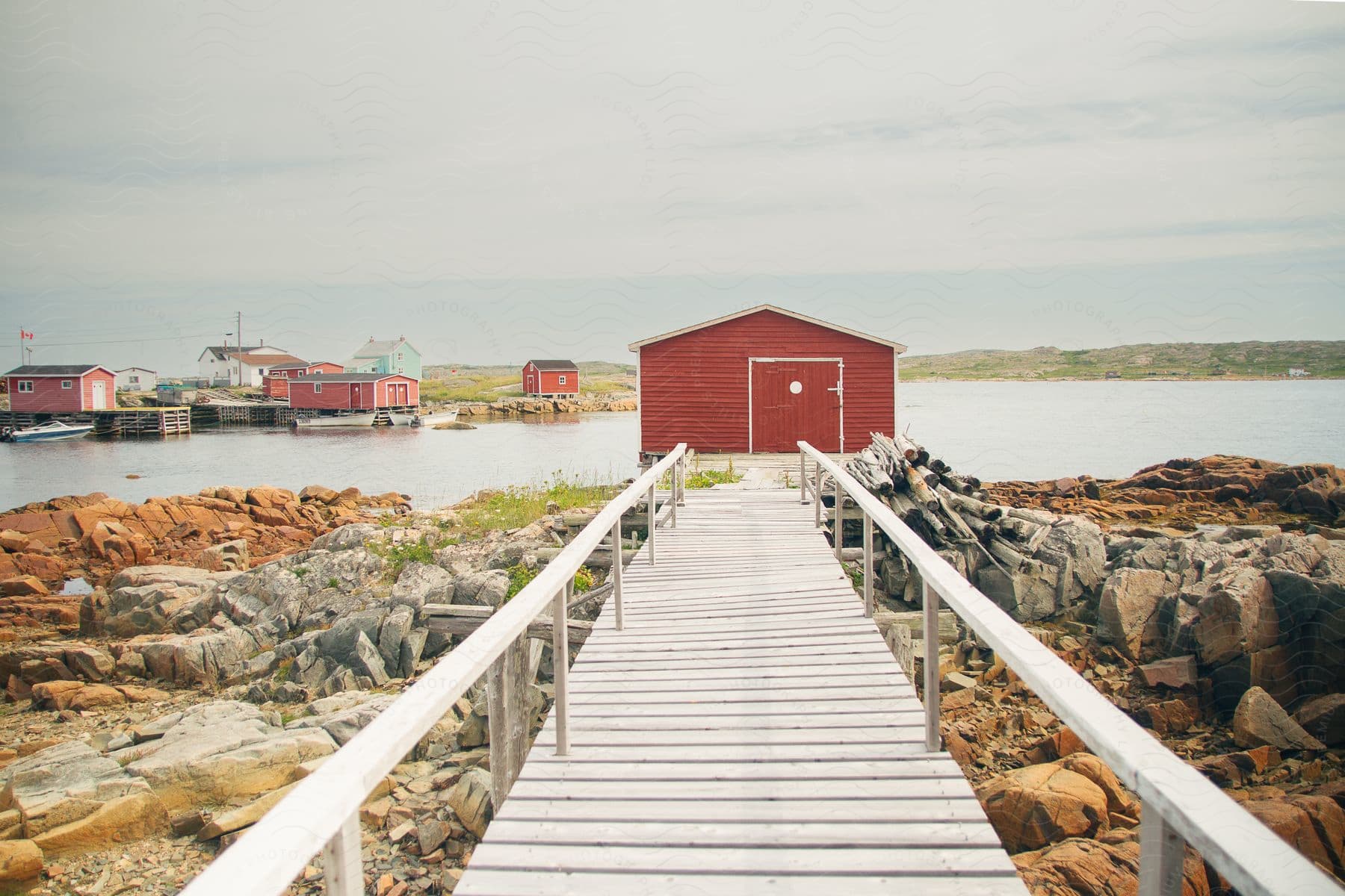 a building close to shore just by the riverbank with a wooden walk path leading to it