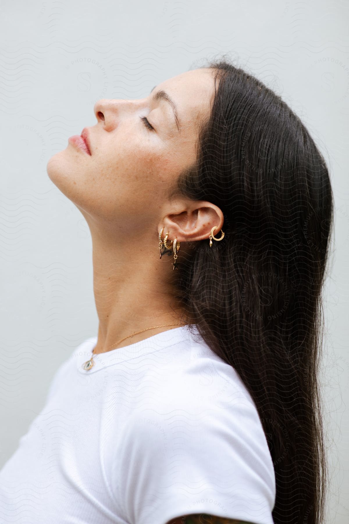 Woman sideways with her eyes closed looking up with her long black hair