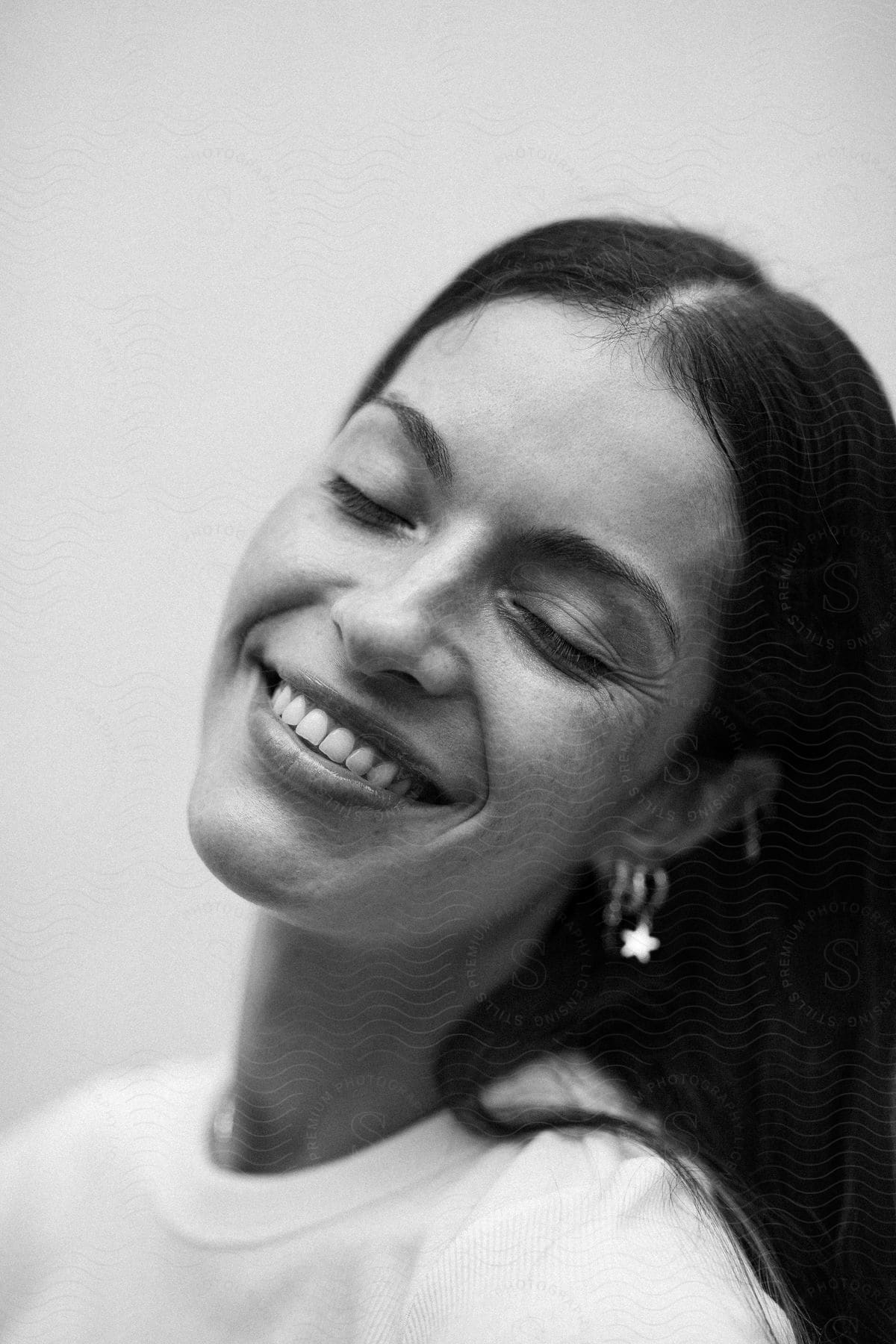 Black and white portrait of a smiling woman with her eyes closed