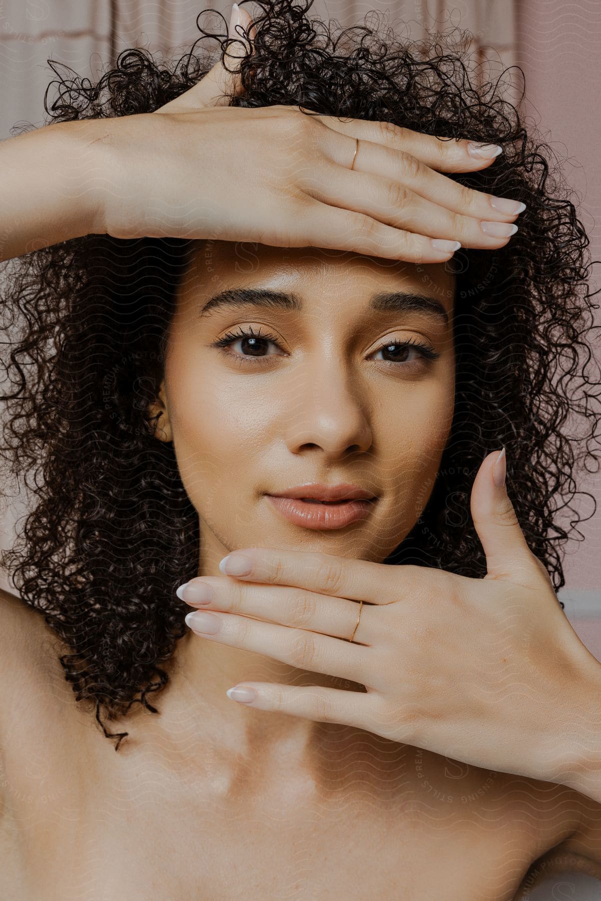 Biracial woman with curly hair vogues for the camera.