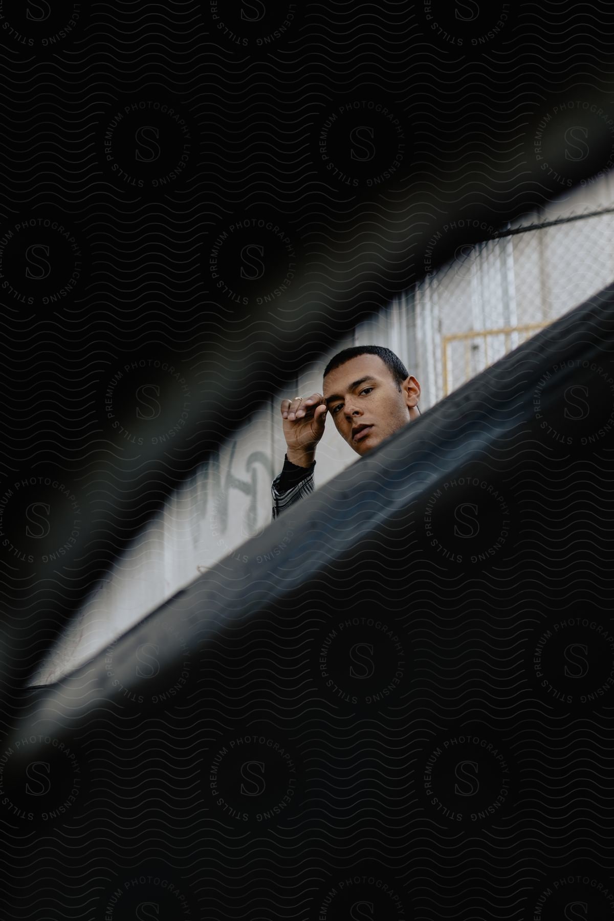 A young man peering into the camera frame.