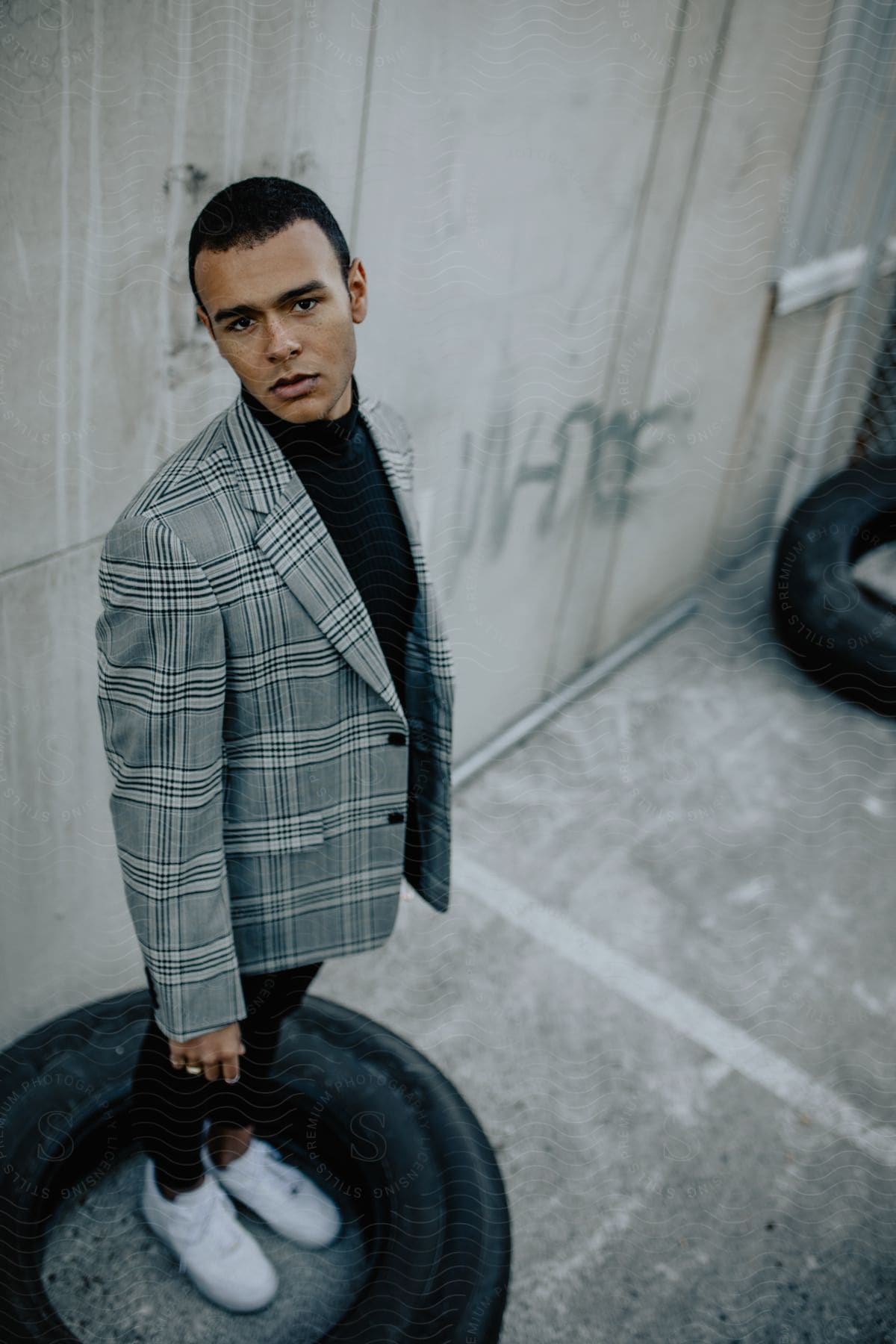 A man standing outdoors modeling a jacket.