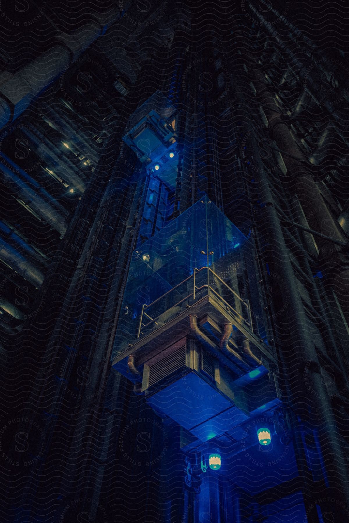 Postmodern architecture of an external glass elevator at night in Lloyd's building