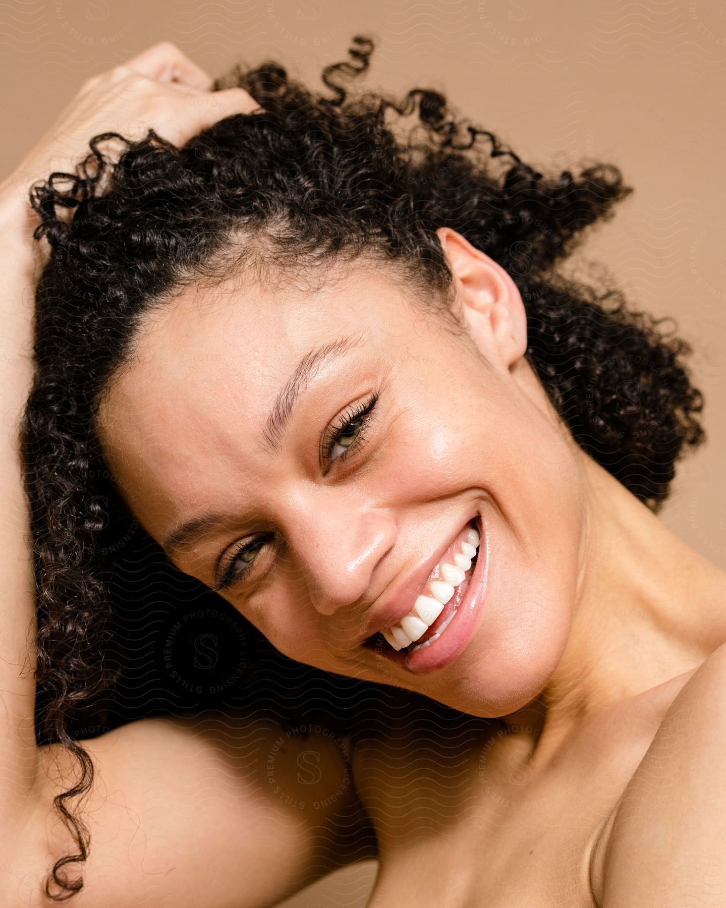 Close up of curly haired woman smiling.