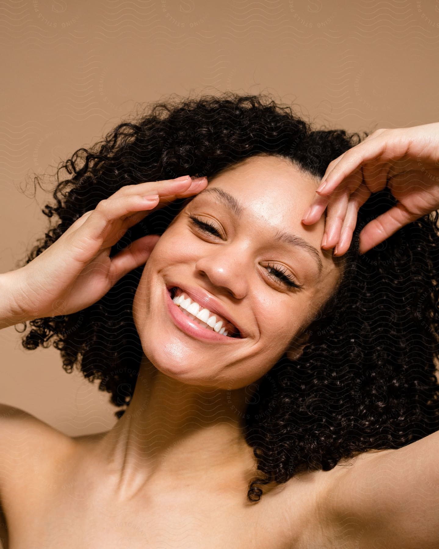 a woman smiling with her hands up.