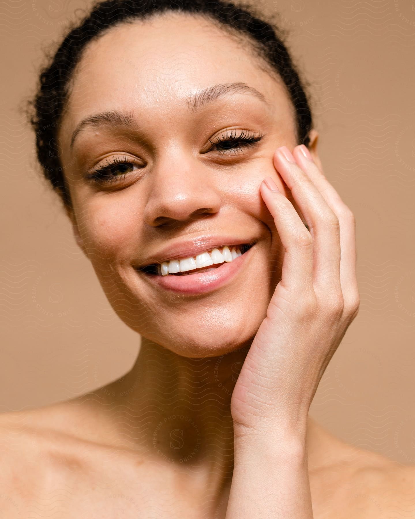 A smiling woman resting her face in her hand.