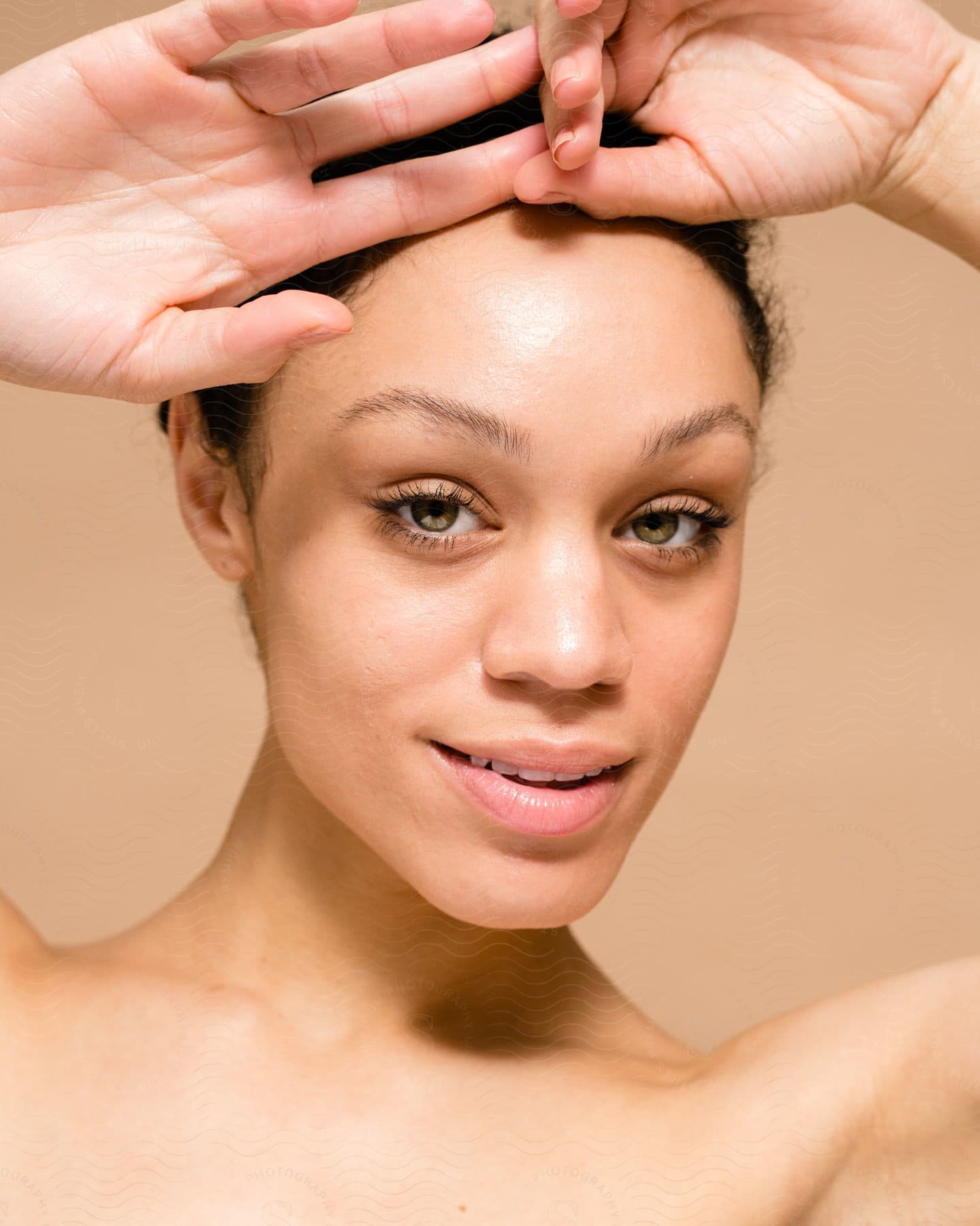 A portrait of a woman modeling some skin care products.