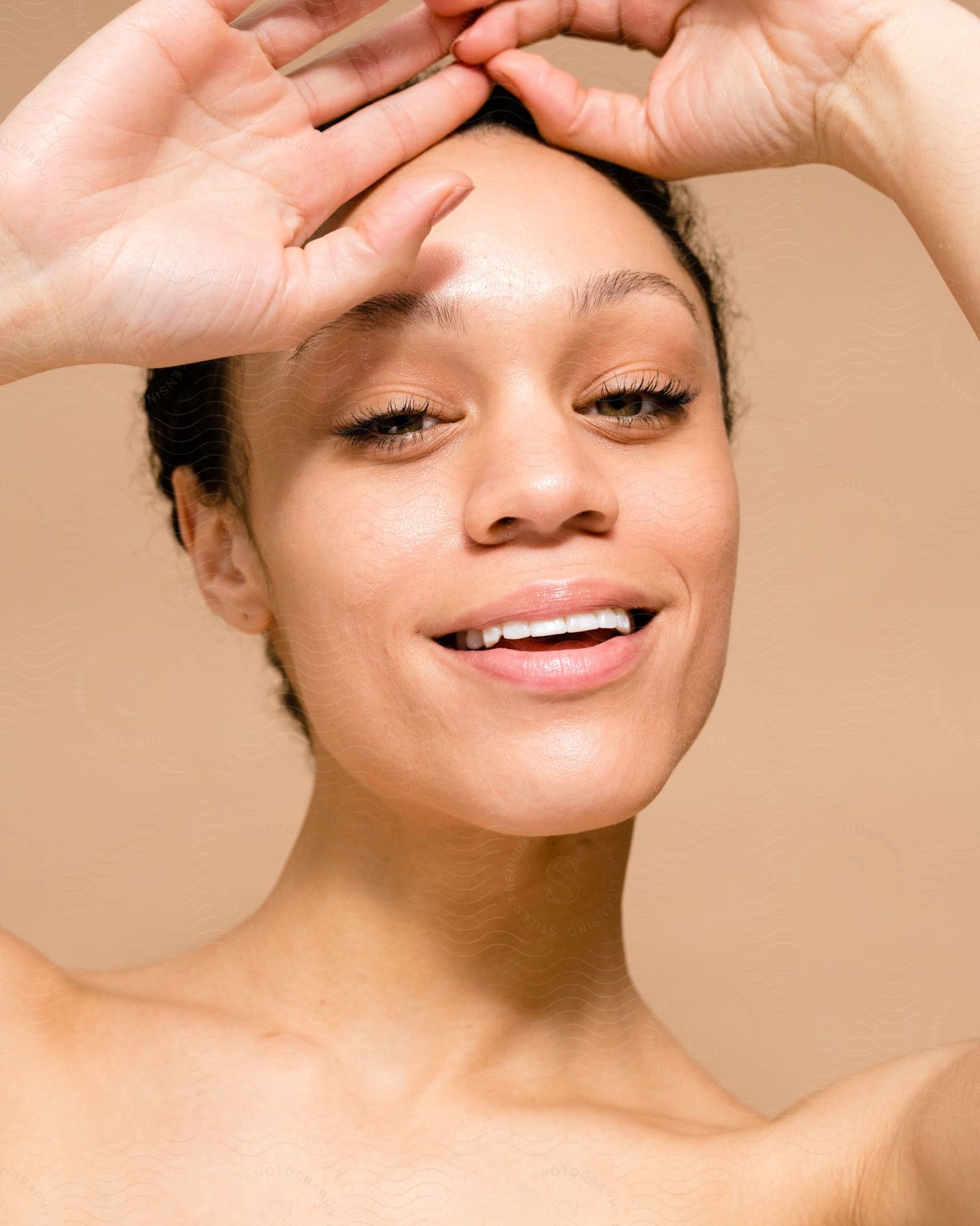 a multi race female placing her hands on her forehead as she smile