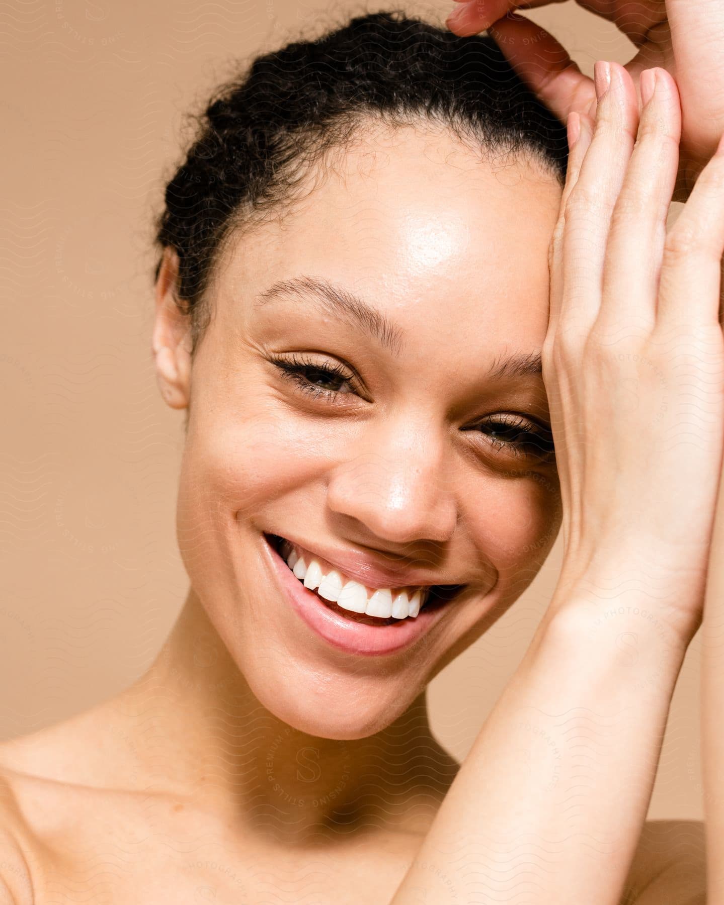 Woman with a big smile on her face and her hands on the side of her forehead