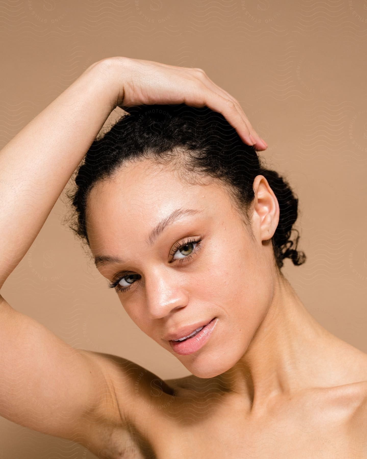 Woman holds her hand on her head as she looks into the camera